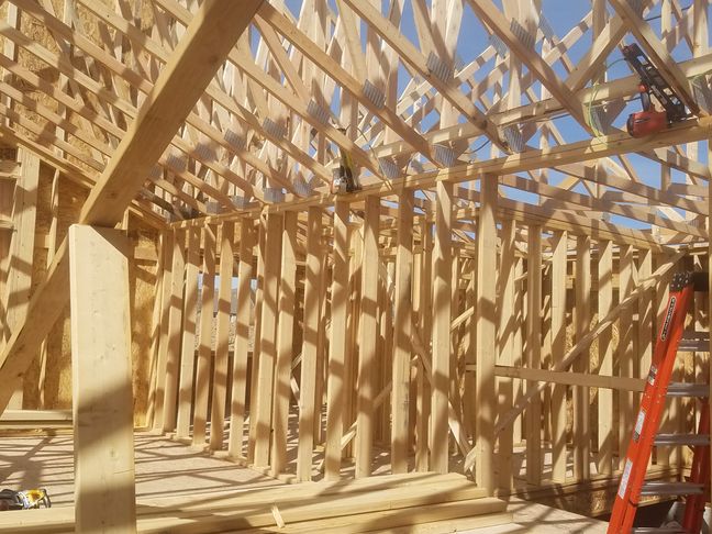 New home framing with engineered trusses and wood studs by Hutch Construction in Bozeman
