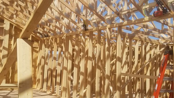 New home framing with engineered trusses and wood studs by Hutch Construction in Bozeman